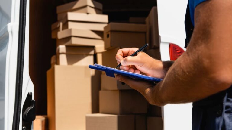 a driver or worker making a tally of materials and items after loading up a moving truck van for business relocation trend purposes