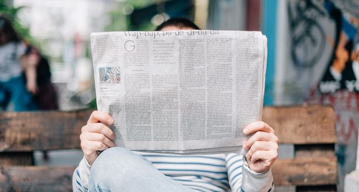 person holding newspaper.jpg.optimal