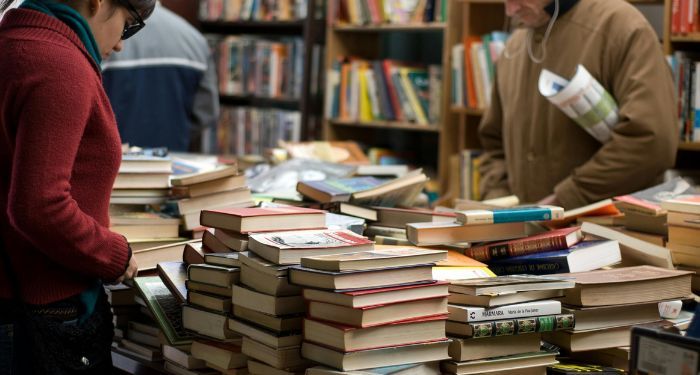 books piled up on a table in a bookstore feature.jpg.optimal